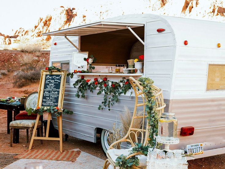 an old camper is decorated with flowers and greenery for the holiday season,