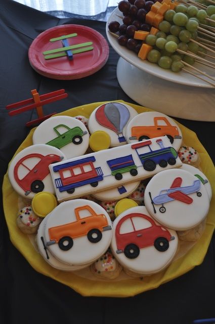 decorated cookies are sitting on a yellow plate next to other desserts and candies