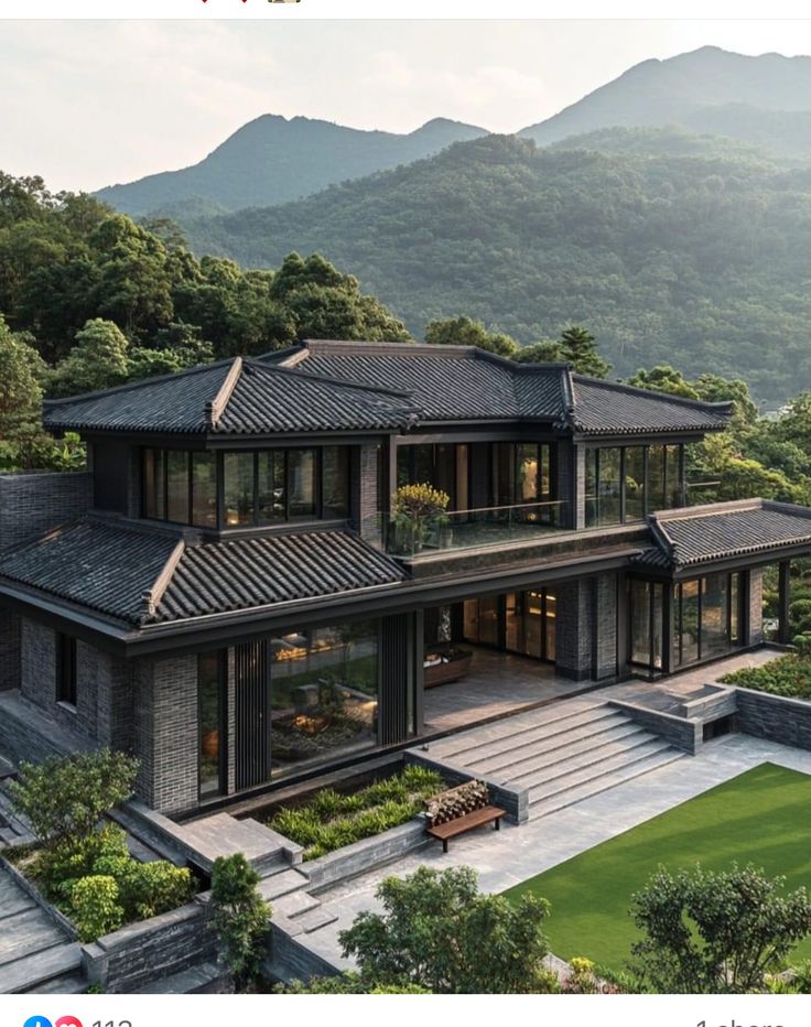 an aerial view of a house with mountains in the background