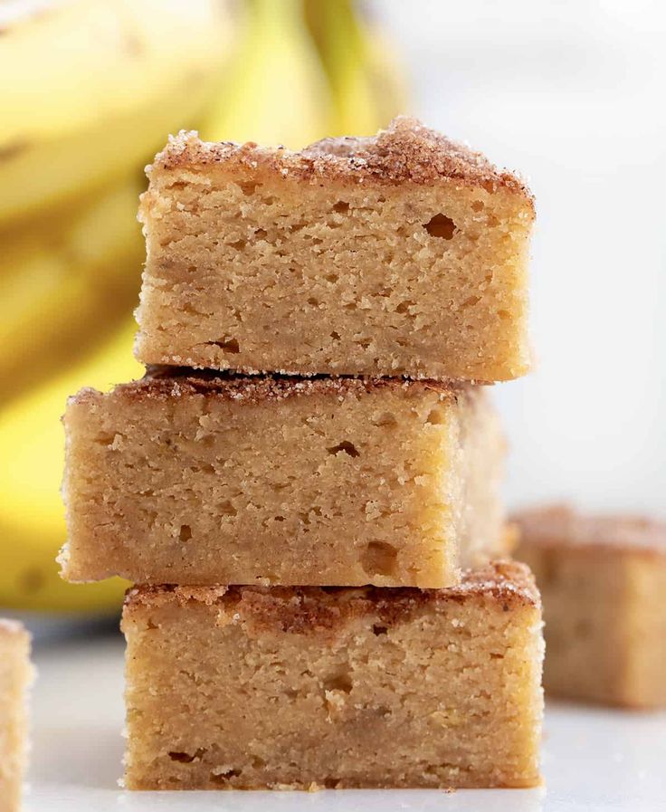 three pieces of cake sitting on top of each other next to a bunch of bananas