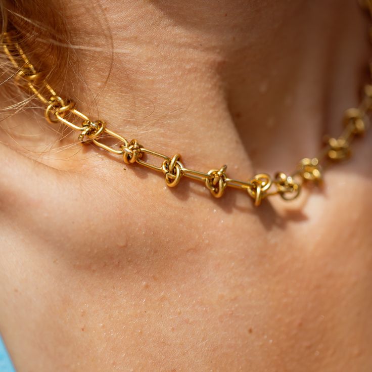 Make waves with our Gold Knotted Barb Wire Chain! This 5mm statement piece is perfect for those who love to blend beachy vibes with bold style. With its knotted design and golden finish, this chain captures the essence of coastal cool while making a striking statement. - 5mm 16 inch knotted chain - 2 inch extender chain + 5mm closed jump ring - Branded lobster clasp - 18k gold plated stainless steel