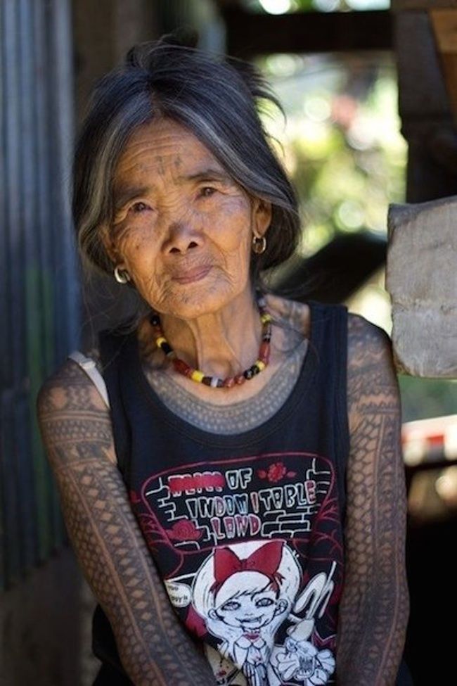 an old woman with tattoos on her arm