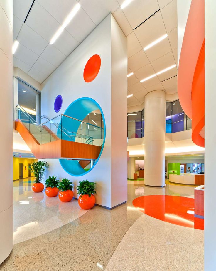 an office building with orange and blue decorations on the walls, potted plants in the foreground