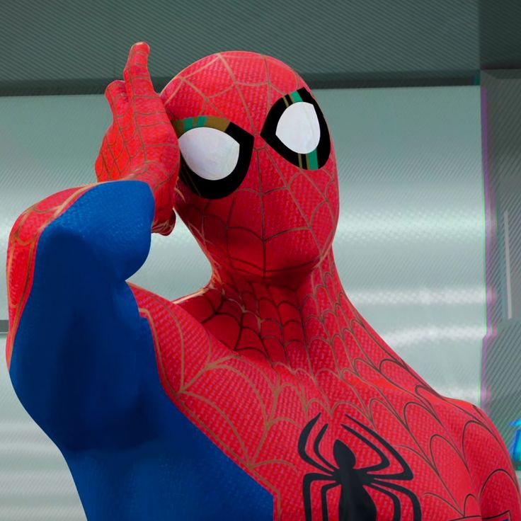 a spider man statue is posed in front of a window with his hand up to his face