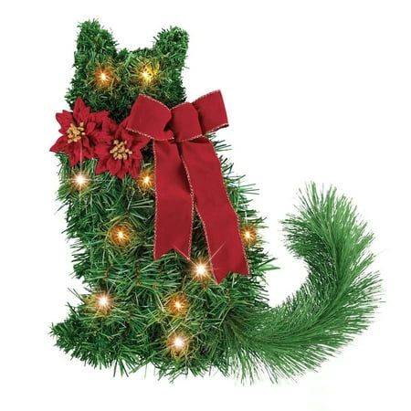 a cat shaped christmas tree with red bows and poinsettis on it's tail