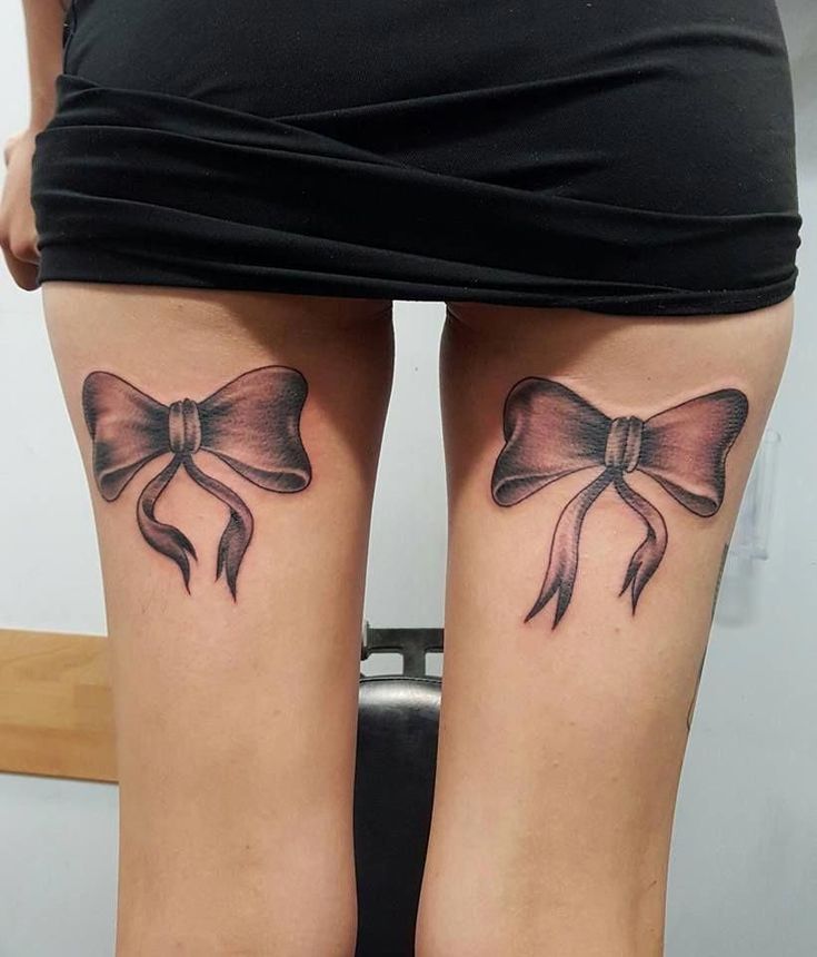 two bow tattoos on both legs, one with a ribbon and the other with a bow