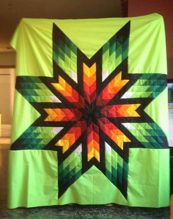 a large green quilt with a star design on it