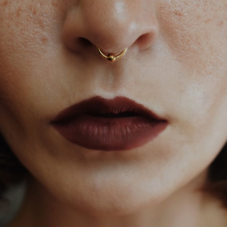 a close up of a woman with a nose ring on it's nose,