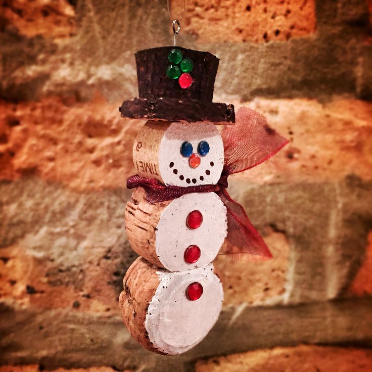 a snowman ornament hanging on a brick wall