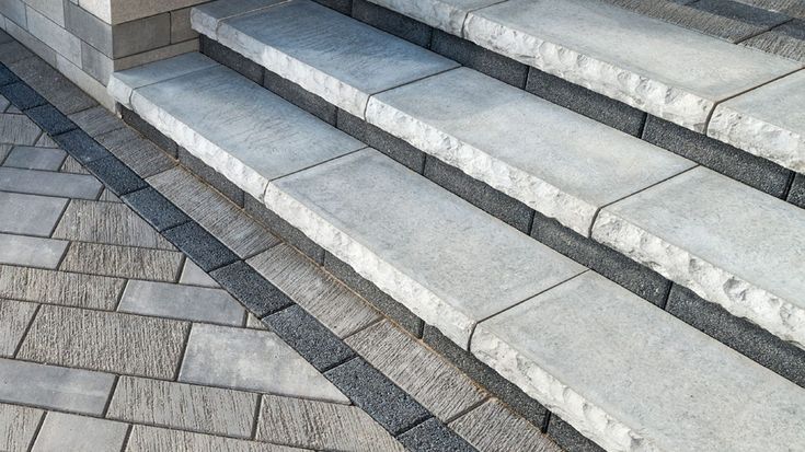 the steps are made of stone and have black lines on them, as well as white bricks