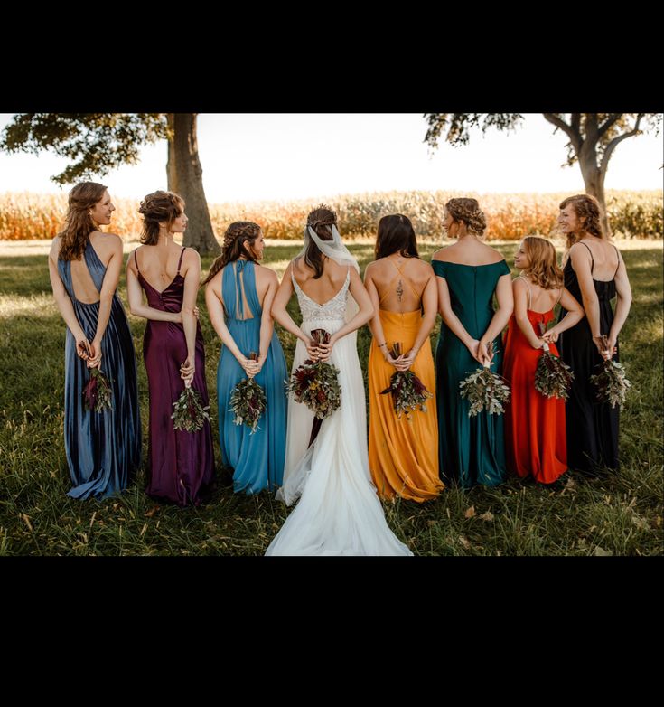 a group of women standing next to each other on top of a lush green field