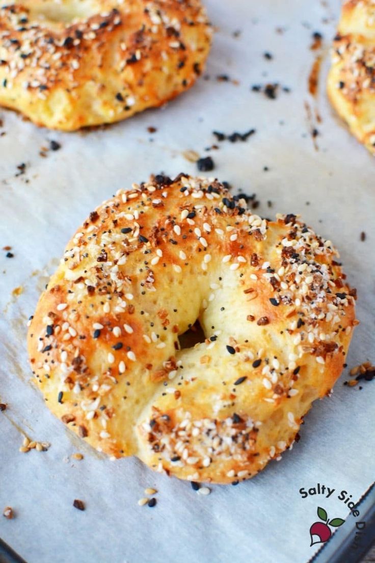 bagels with sesame seeds and poppy seed sprinkles on a baking sheet