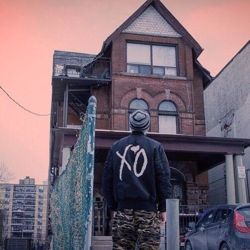 a man standing on the sidewalk in front of a house