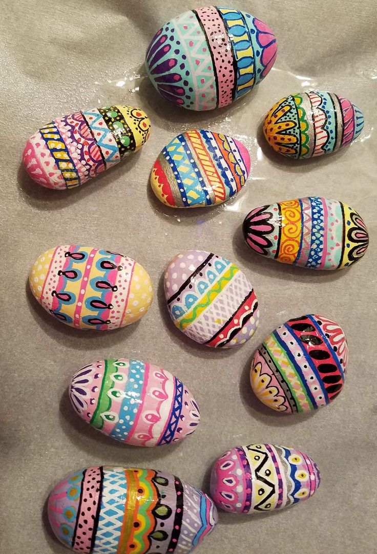 several colorful painted rocks sitting on top of a white table covered in plastic wrappers