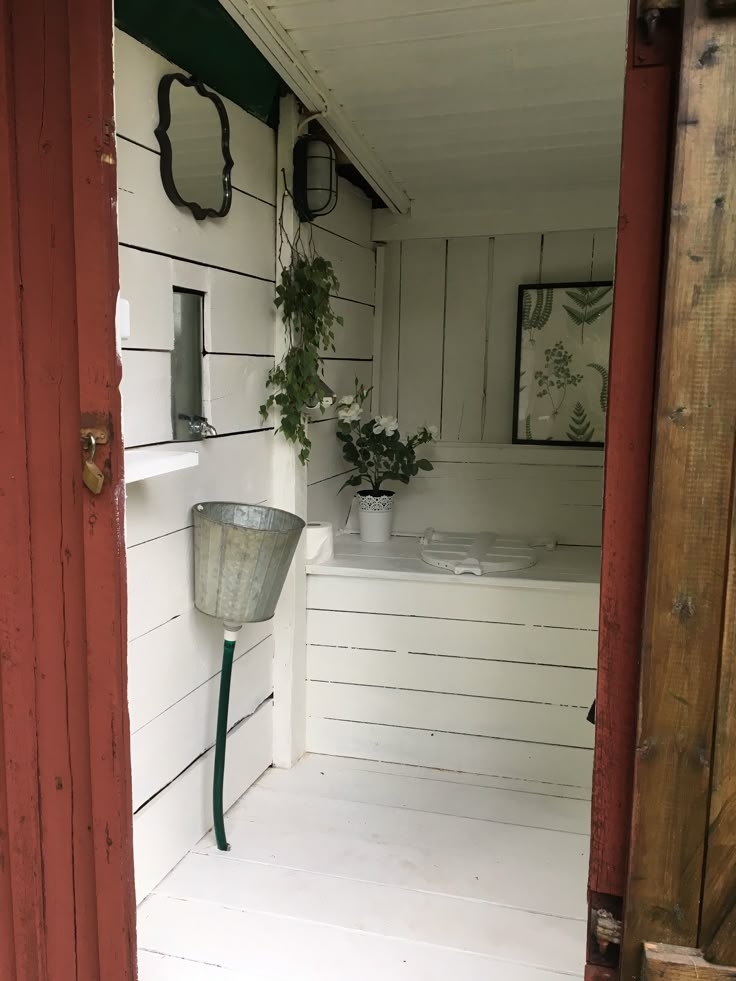 an open door leading to a bathroom with potted plants