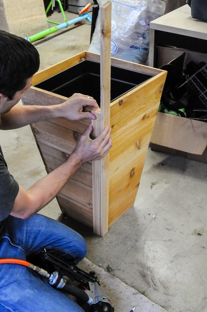 a man working on a wooden planter box