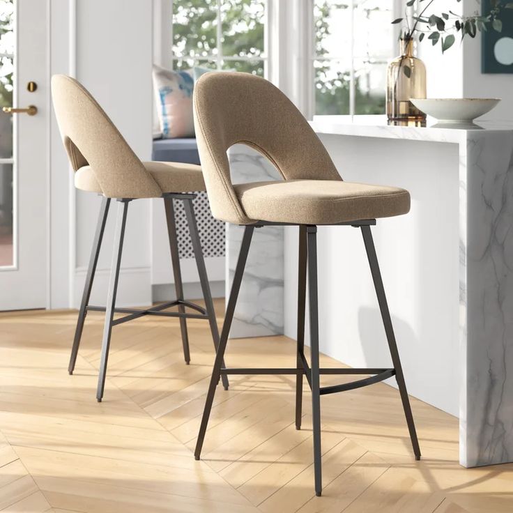 two stools sitting on top of a hard wood floor next to a kitchen counter