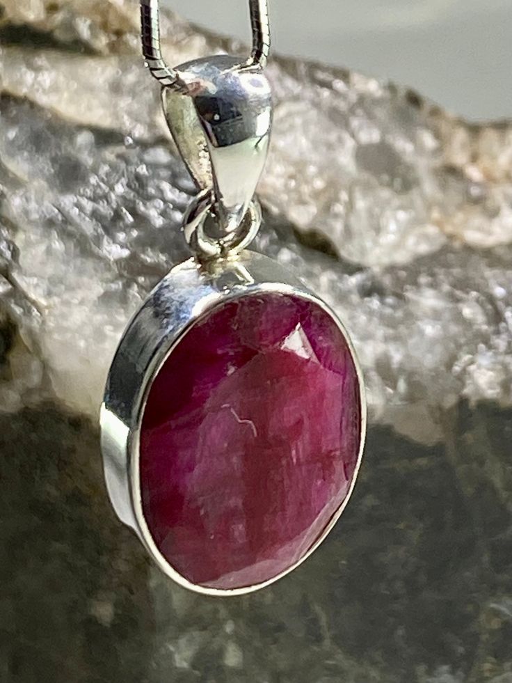 An exquisite Raw Red Ruby and silver pendant. The stone is a good size, of a beautifully deep vivid ruby red, oval-cut and set in the classic bezel.  The pendant measures - 2.1cm Long x 1.5cm wide x 0.6cm deep. Weight - 6 grams. This pendant is made utilising hypoallergenic pure 925 silver that is nickel, lead and cadmium free. Customer can choose to purchase the pendant in the following options: 1 - The pendant separately.  2 - The pendant Including the stunning solid Italian silver 1mm diamete Classic Ruby Round Pendant Jewelry, Classic Round Ruby Pendant Jewelry, Faceted Oval Ruby Jewelry, Oval Faceted Ruby Jewelry, Oval Ruby Jewelry With Faceted Detail, Ruby Cabochon Pendant Jewelry, Red Faceted Oval Jewelry, Red Ruby Cabochon Necklace, Red Oval Faceted Jewelry