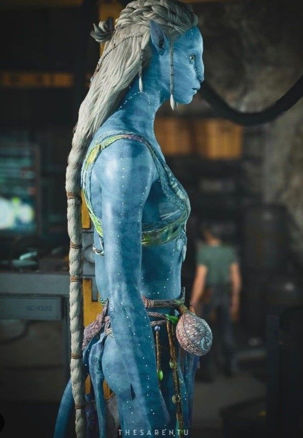 a woman with blue paint on her body and braids