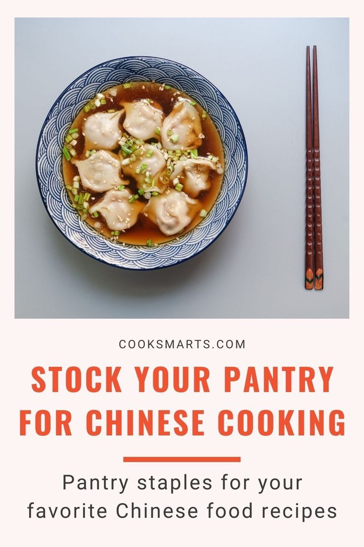 a blue and white bowl filled with dumplings next to chopsticks on top of a table