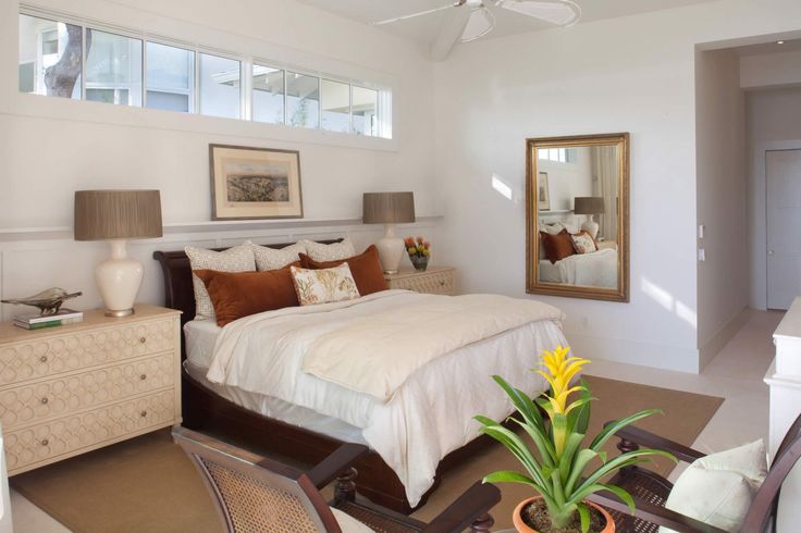 a bedroom with a bed, dressers and mirror in it's center area