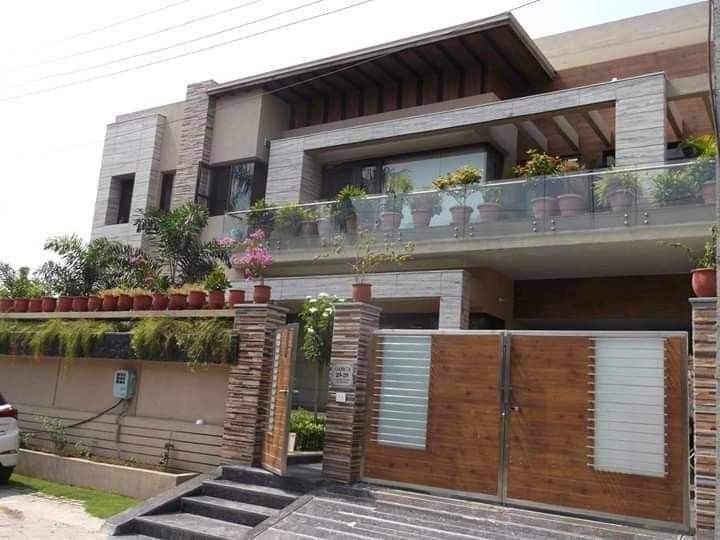 a car parked in front of a house with plants on the balcony and balconies