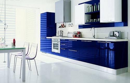 a kitchen with blue and white cabinets, counter tops, chairs and a dining table