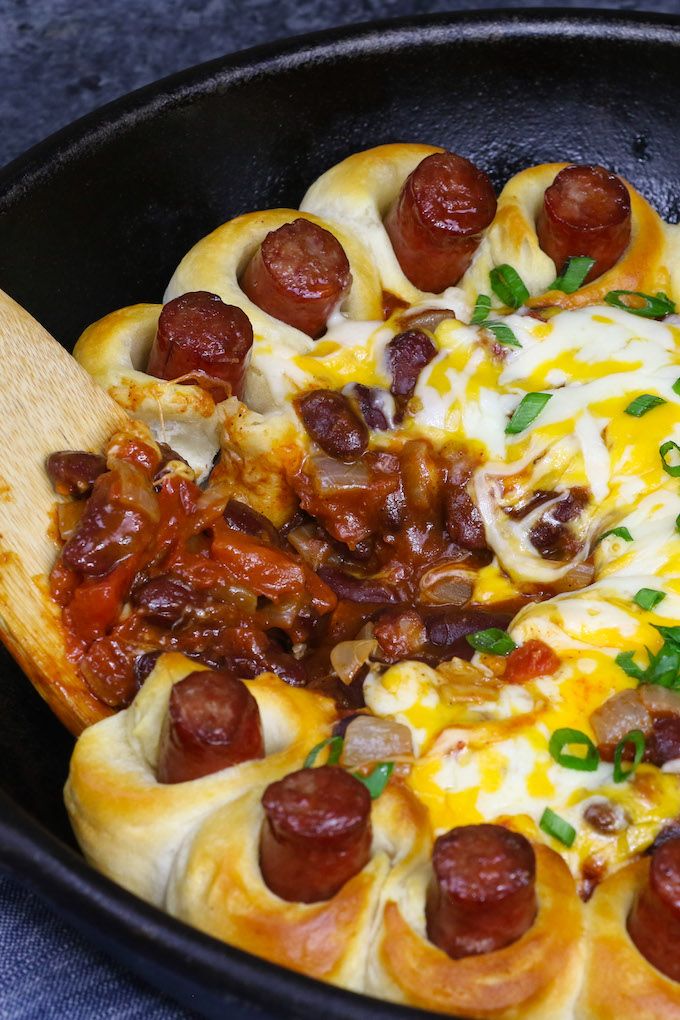 a skillet filled with hot dogs and cheese