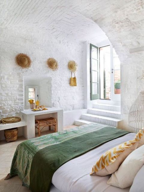 a bedroom with white walls and green bedspread