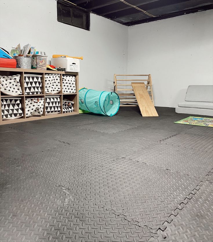 an empty garage with several storage bins on the floor