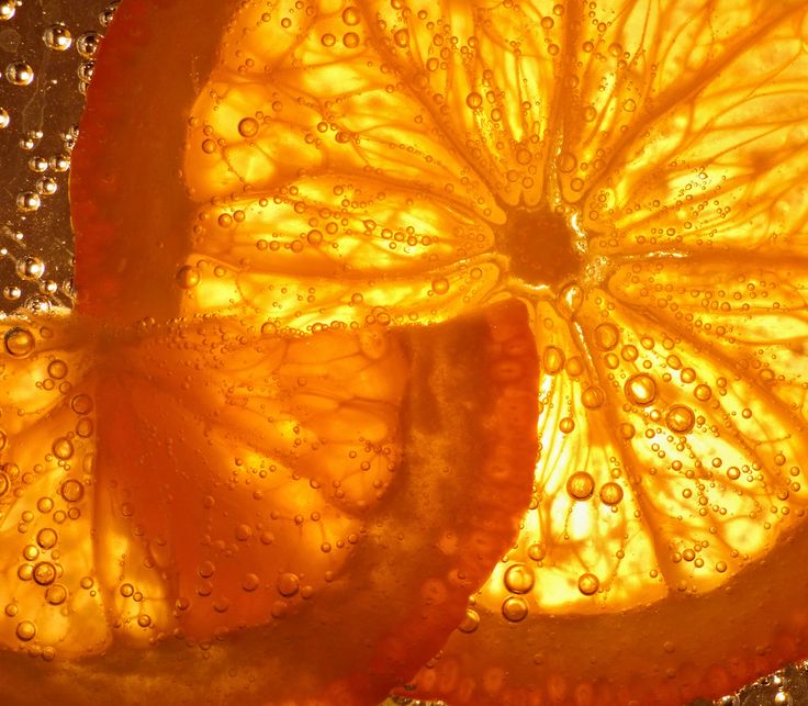 an orange cut in half with water droplets on it