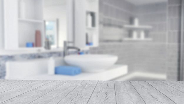 an empty wooden table in front of a bathroom