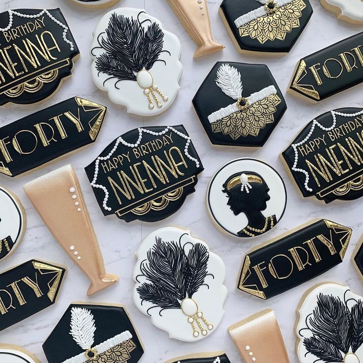 decorated cookies with black and gold accents on a white tablecloth are shown in the shape of women's names