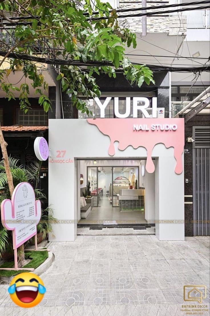 the entrance to yurh nail studio with pink and white paint dripping down it's walls