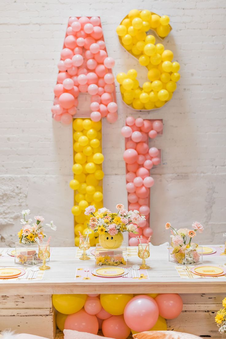 a table with balloons and flowers on it