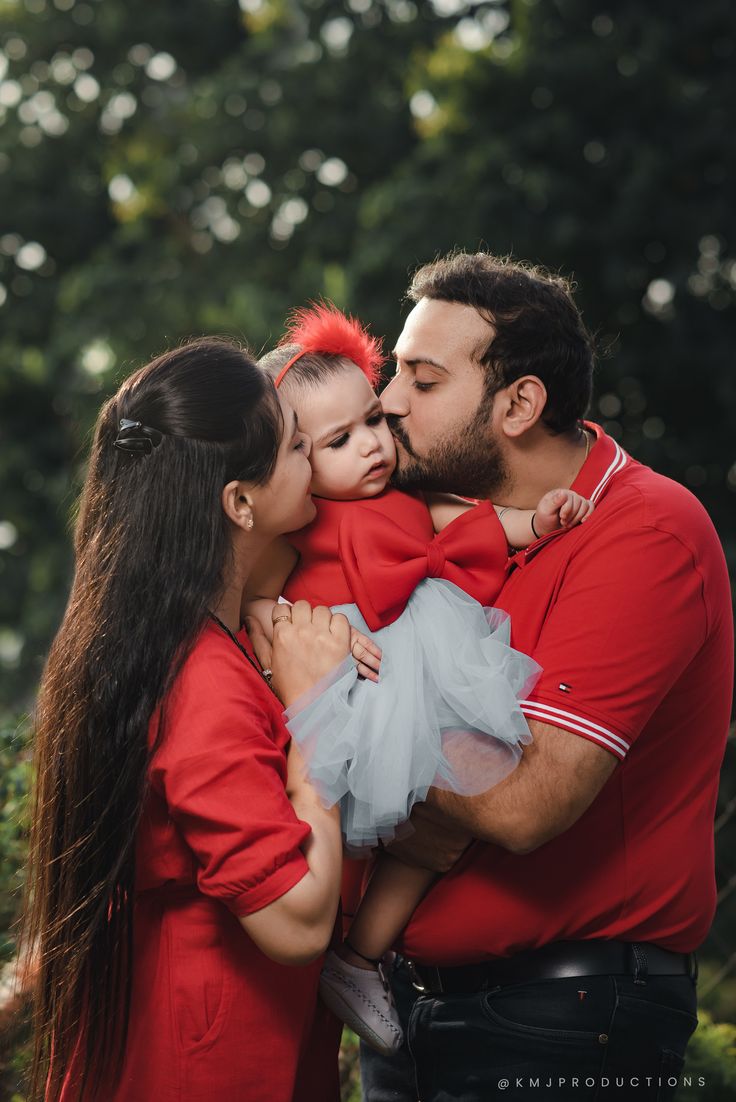 a father kissing his two daughters on the cheek