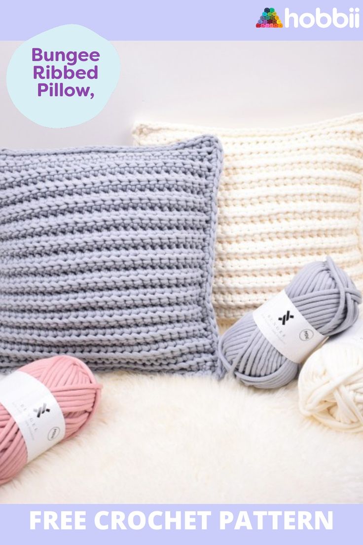 a crochet pillow with two balls of yarn next to it