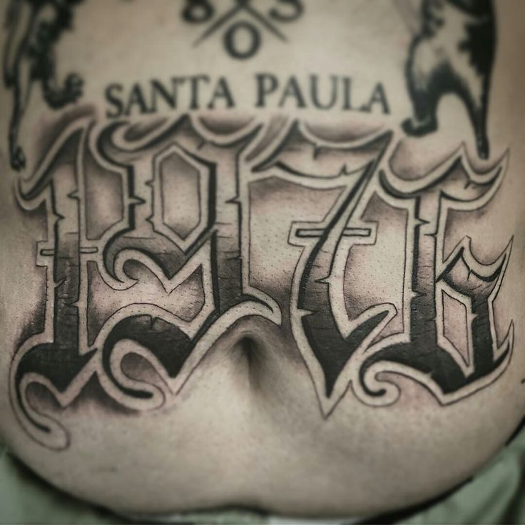 the back of a man's stomach with tattoos on it and words written in black ink