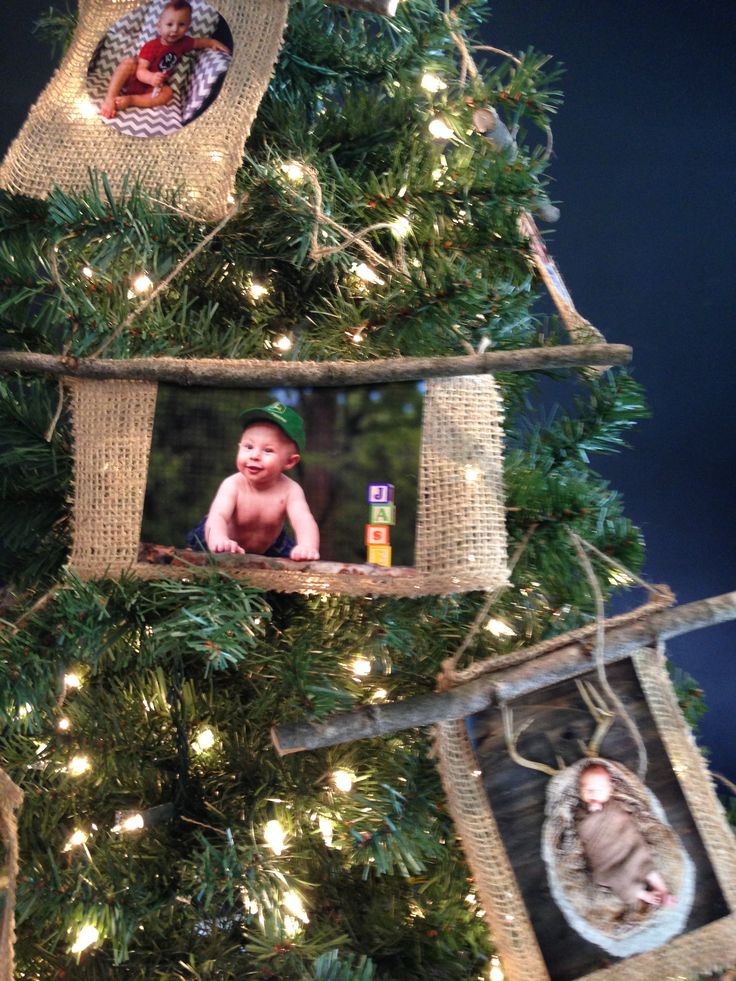 a christmas tree decorated with pictures and twine frames for babies to hang on it