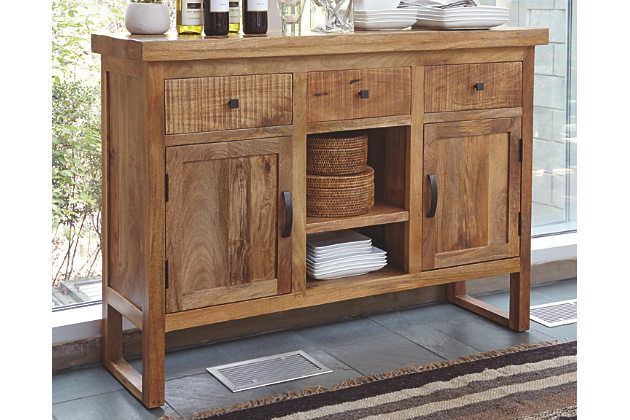 a wooden sideboard with baskets and dishes on it