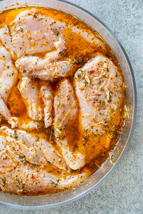 some meat is cooking in a pan on the counter top with spices and seasoning