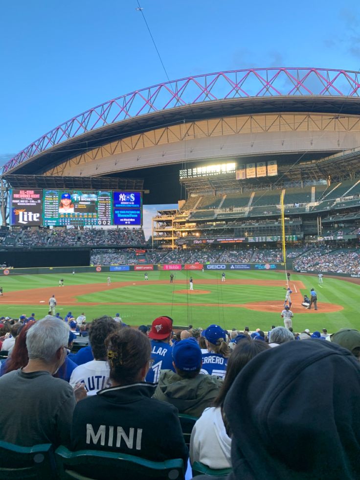 a baseball game is being played in a stadium with many people sitting on the bleachers