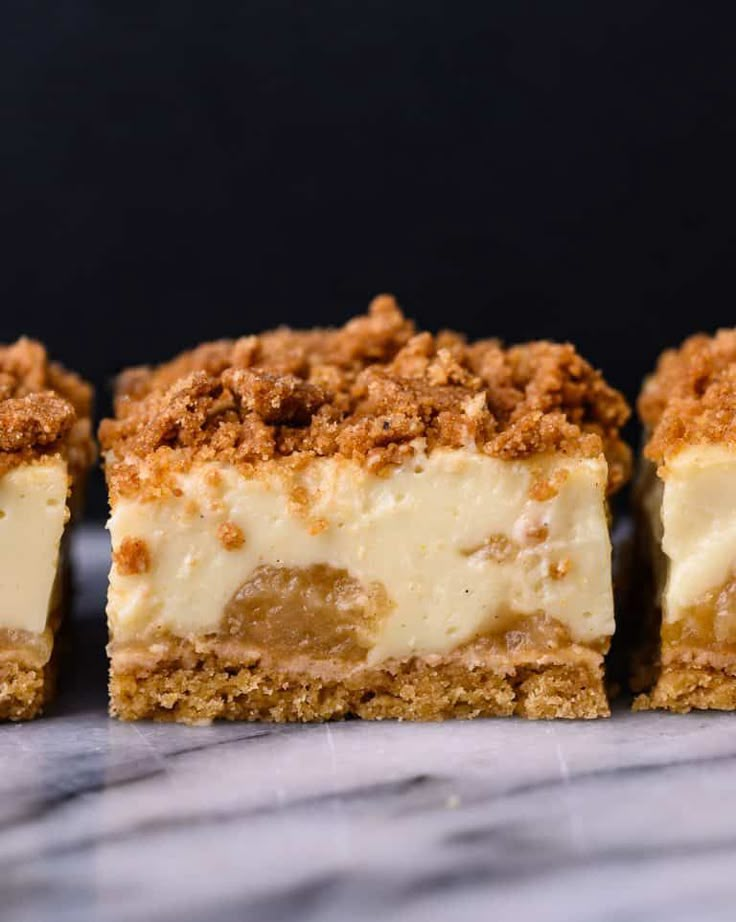 three pieces of cheesecake sitting on top of a marble counter