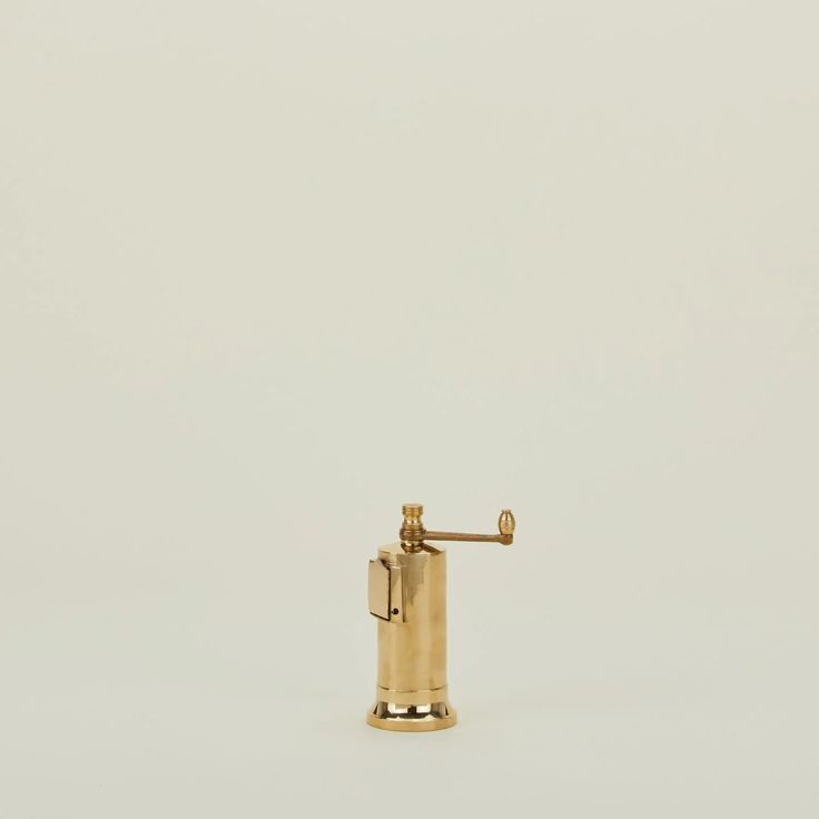 a gold colored soap dispenser is shown against a white background with no one around it