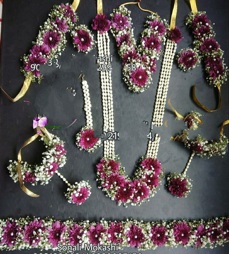 flowers and ribbons are laid out on a black surface with gold ribbon around the edges