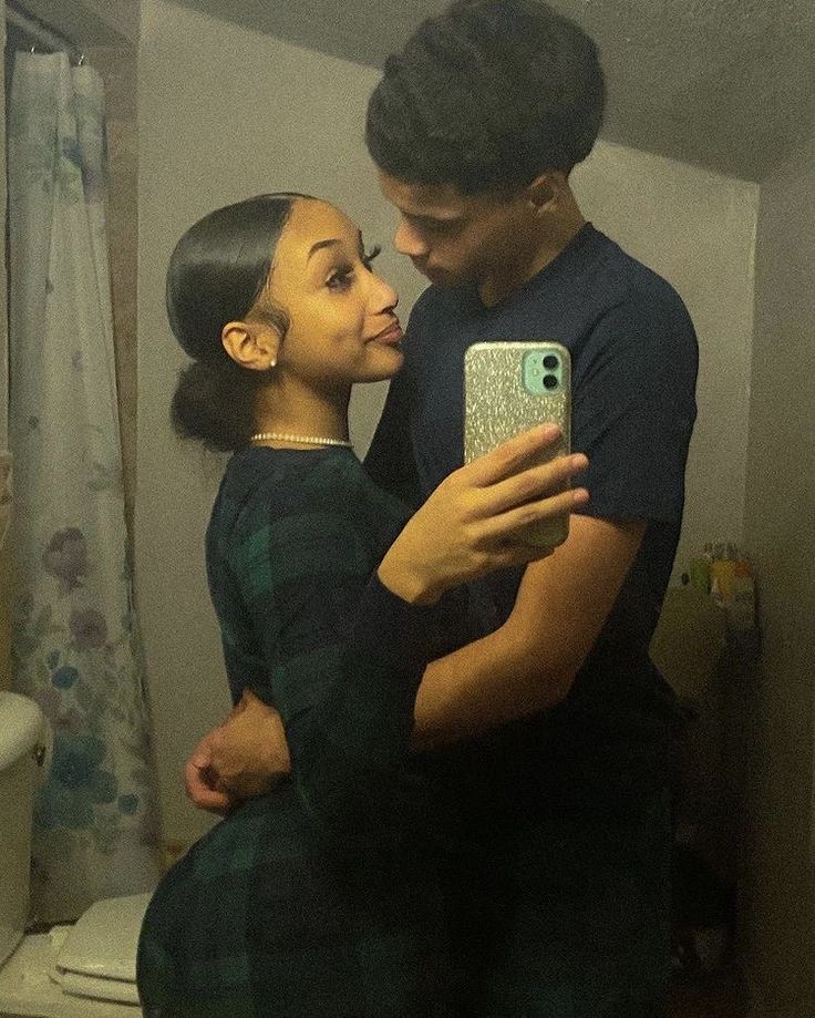 a man and woman are taking a selfie in the bathroom while holding their cell phone