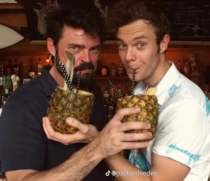 two men are holding pineapples in their hands