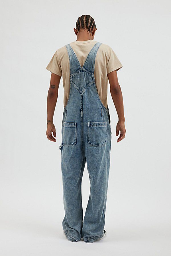 Baggy fit overalls by the essential BDG denim label. Classic bib front overalls with adjustable shoulder straps and utility pockets. Urban Outfitters exclusive. Features BDG Nitro baggy overall Workwear bib front overalls Adjustable shoulder straps Pouch front pocket Utility pockets UO exclusive Content + Care 100% Cotton Machine wash Imported Size + Fit Model in Charcoal is 6’2" and wearing size 32 Measurements taken from size 32 Length: 65" Rise: 13.5" Inseam: 29" Leg opening: 11" | BDG Nitro Denim Overalls With Side Pockets And Relaxed Fit, Medium Wash Relaxed Fit Overalls With Pockets, Relaxed Fit Denim Jumpsuit With Bib Front And Pockets, Relaxed Fit Denim Jumpsuit With Bib Front, Utility Overalls With Patch Pockets, Utility Style Denim Overalls With Straight Leg, Utility Overalls In Medium Wash With Pockets, Utility Style Denim Jumpsuit With Pockets, Utility Denim Overalls With Straight Legs