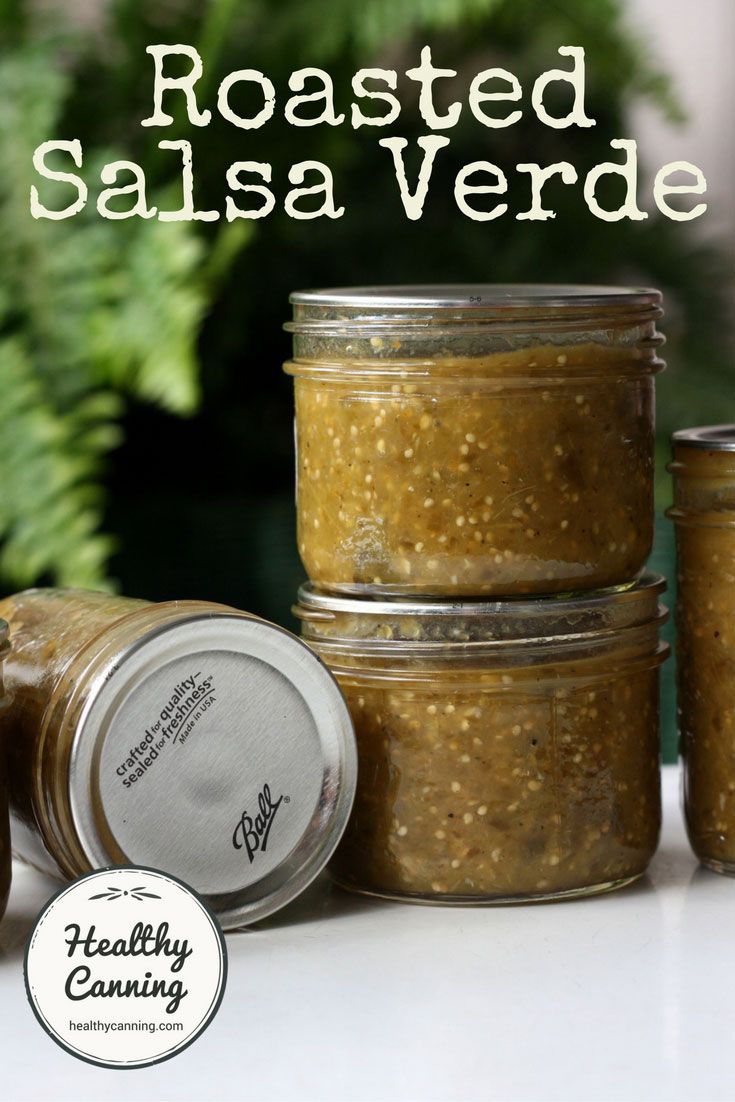 three jars filled with salsa sitting on top of a table next to plants and a potted plant