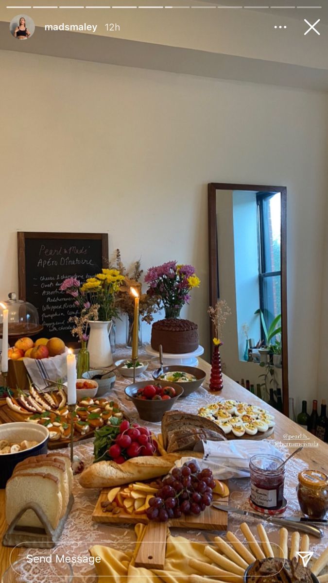 a table filled with lots of food on top of a white table covered in candles